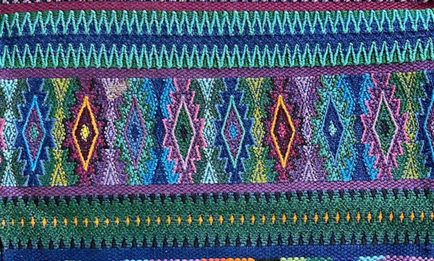 a closeup of a multicolored guatemalan textile with a diamond pattern